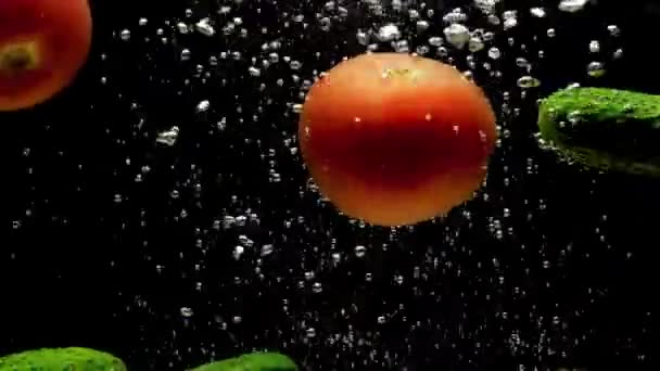 Tomates Pepinos Caem Água Transparente Fundo Preto Legumes Orgânicos Frescos — Vídeo de Stock