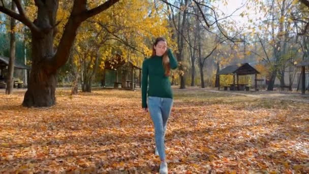 Молодая Привлекательная Брюнетка Гуляет Парку Фоне Пожелтевших Осенью Деревьев Красивая — стоковое видео