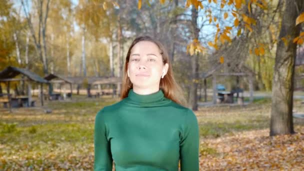 Młoda Atrakcyjna Brunetka Bezprzewodowymi Słuchawkami Spaceruje Jesienią Parku Tle Żółtych — Wideo stockowe
