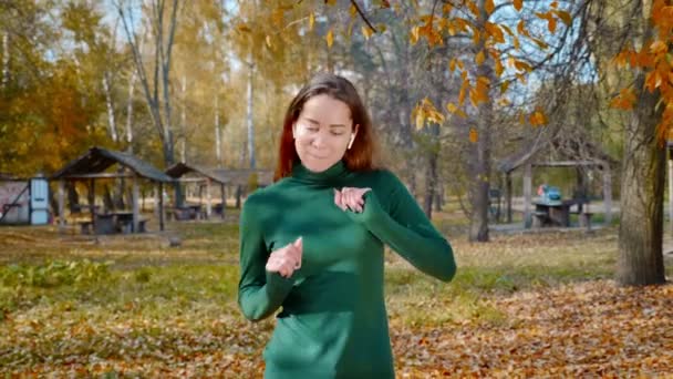 Genç Çekici Esmer Kadın Sonbaharda Kablosuz Kulaklıkla Müzik Dinliyor Sarı — Stok video