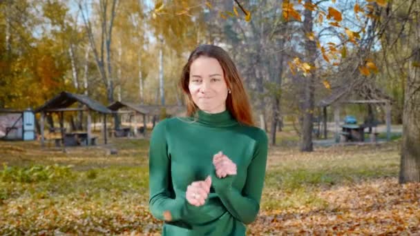 매력적 헤드폰으로 음악을 가을에는 나무들을 공원에서 스웨터를 — 비디오