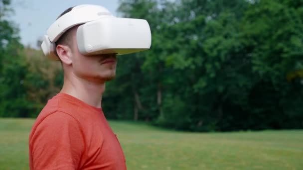 El hombre en un casco de realidad virtual gira la cabeza hacia la derecha — Vídeo de stock