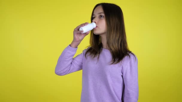 Mädchen trinkt Joghurt mit Flasche für Milchprodukte, dreht sich in die Kamera und lächelt — Stockvideo