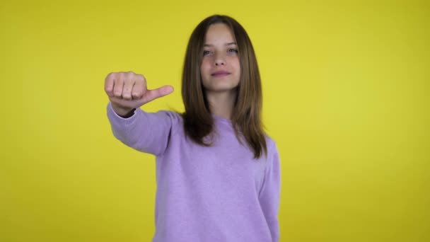 Vom Guten zum Schlechten. Teen girl zeigt wie und lächelt dann zeigt Abneigung und runzelt die Stirn — Stockvideo
