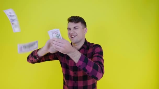 Reicher Mann im rosa karierten Hemd wirft Geld auf gelben Hintergrund — Stockvideo