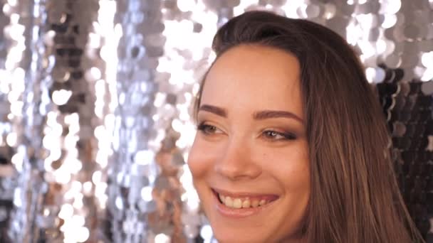 Close-up vrouw met mooie make-up is lachen op een glanzende zilveren achtergrond — Stockvideo