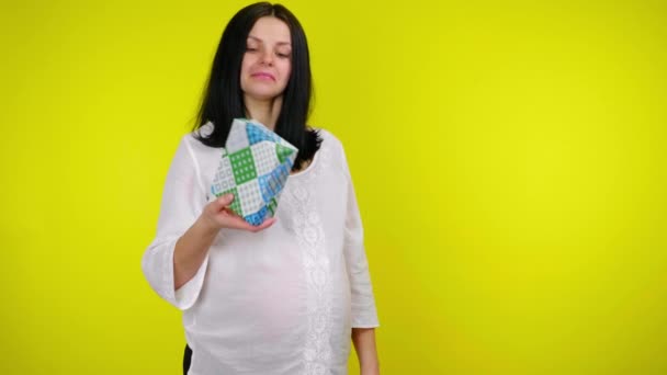 Femme enceinte examine une boîte avec un cadeau et essaie de comprendre ce qui est à l'intérieur — Video