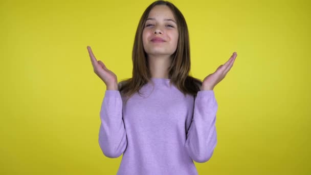 Adolescente menina levanta as mãos para cima, descansando palmas nos lábios, em seguida, pega e sorri — Vídeo de Stock