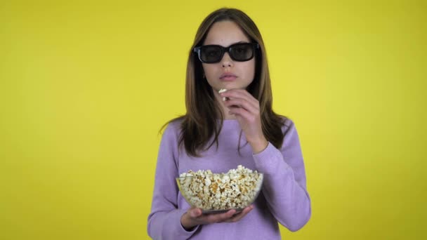 Chica ve la película en gafas 3D, come palomitas de maíz y no está contento con el sabor — Vídeos de Stock