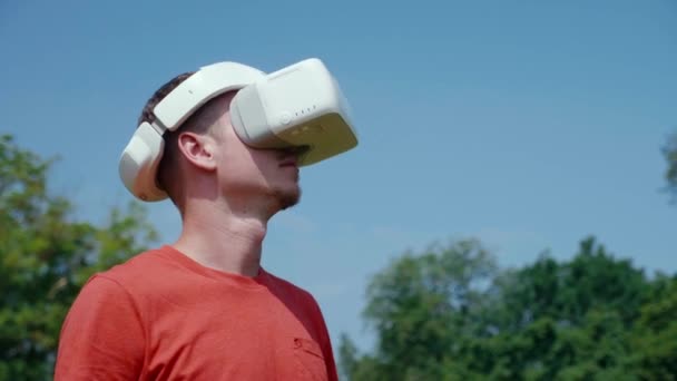 L'uomo in un casco realtà virtuale sta studiando un gioco virtuale — Video Stock