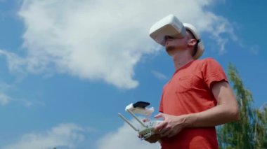 Adam bir kuadrokopteri uzaktan kumandayla kontrol ediyor.