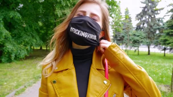 Woman takes off a black mask, closes the camera lens with hand in a white glove — Stock Video