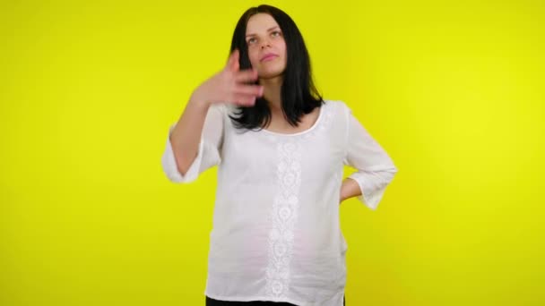 Ernstige rijke jonge zwangere vrouw gooit veel geld op gele achtergrond — Stockvideo