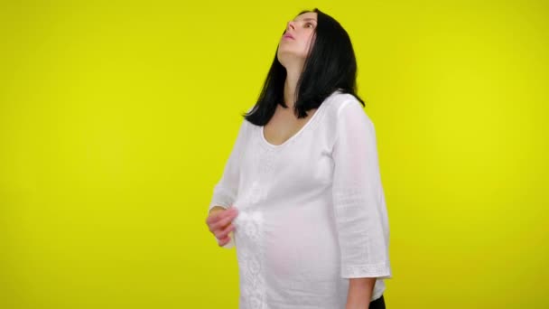 Fiatal terhes nő fehér blúzban nagyon forró sárga alapon — Stock videók