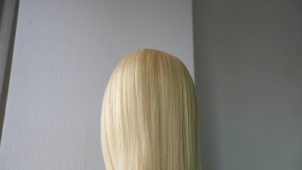 Красивый парик с прямыми белыми волосами стоит в салоне красоты — стоковое видео