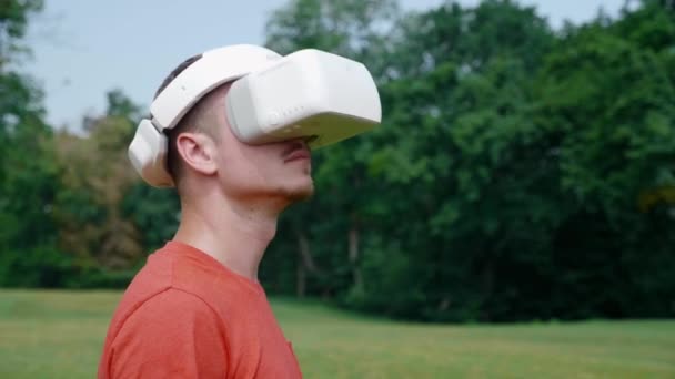 El hombre en un casco de realidad virtual gira la cabeza hacia la derecha y hacia arriba — Vídeo de stock