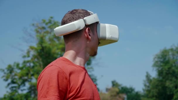 Homme dans un casque de réalité virtuelle étudie un jeu virtuel — Video