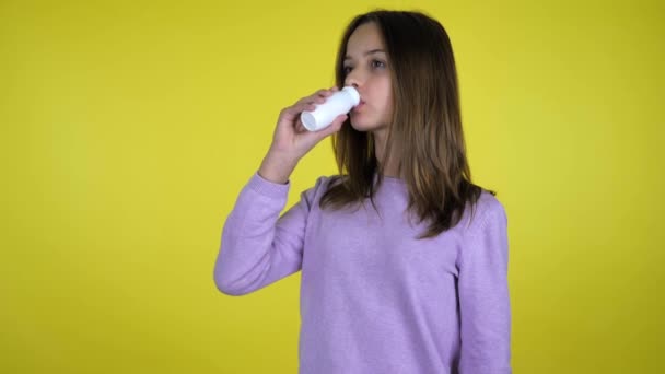 Meisje drinkt yoghurt met fles, draait zich om de camera, glimlacht en toont als — Stockvideo