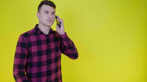 Man accepteert bellen, houdt smartphone aan het oor, praat over de telefoon en knikt hoofd — Stockvideo