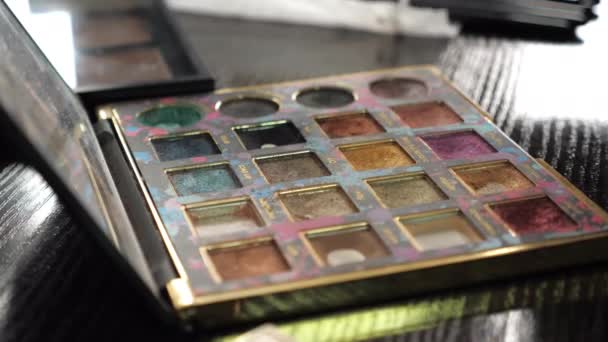 Paleta multicolor de la sombra de ojos del maquillaje del primer plano en un salón de belleza — Vídeos de Stock