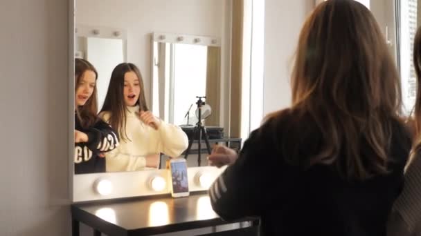 Κορίτσια χορεύουν μπροστά από έναν καθρέφτη, καταγράφουν βίντεο σε μια κάμερα selfie του smartphone — Αρχείο Βίντεο