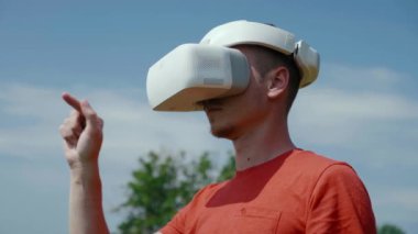 Adam kafasına sanal gerçeklik kaskı takıyor ve hareketleri kontrol ediyor.