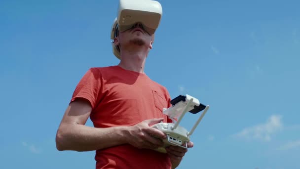 Człowiek kontroluje drona za pomocą pilota zdalnego sterowania — Wideo stockowe