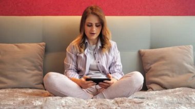 Kadın duygusal olarak akıllı telefondan video oyunu oynuyor, kazanıyor, zaferle seviniyor.