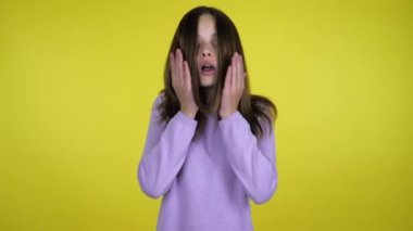 Genç kız başını kaldırdı ve şok oldu. Avuç içlerini sarı arka plana koydu.