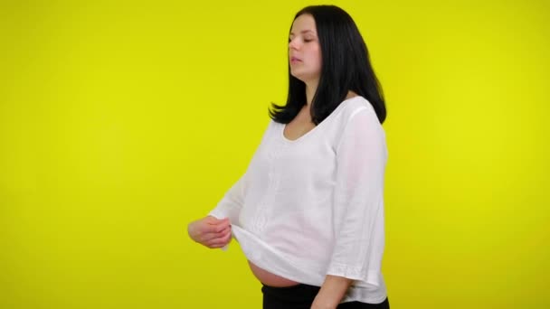 It is very hot for a young pregnant woman, drinking water from a plastic bottle — Stock Video