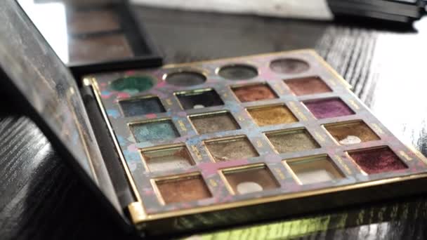 Paleta multicolor de la sombra de ojos del maquillaje del primer plano en un salón de belleza — Vídeos de Stock