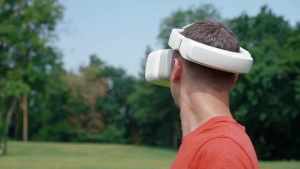 Чоловік у шоломі віртуальної реальності повертає голову вправо — стокове відео