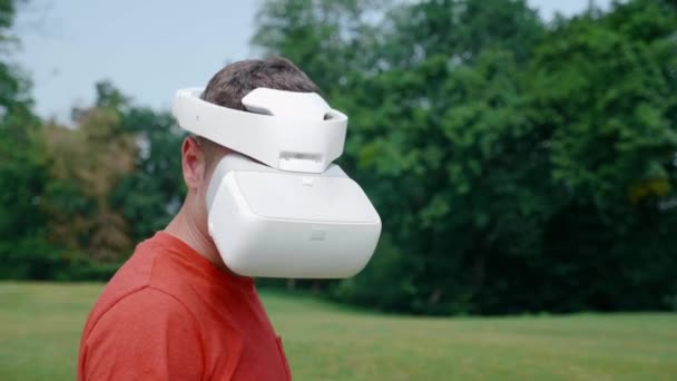 L'uomo in un casco realtà virtuale gira la testa verso destra e verso il basso — Video Stock