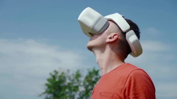 Ο άνθρωπος σε ένα κράνος εικονικής πραγματικότητας γυρίζει το κεφάλι πάνω και προς τα δεξιά — Αρχείο Βίντεο