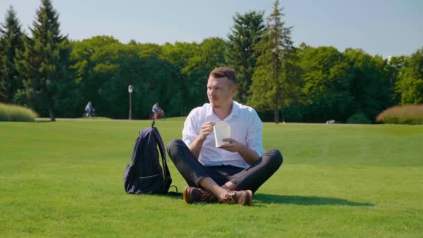 Homme mange le déjeuner végétarien avec un paquet écologique, fronçant les sourcils et montrant dégoût — Video