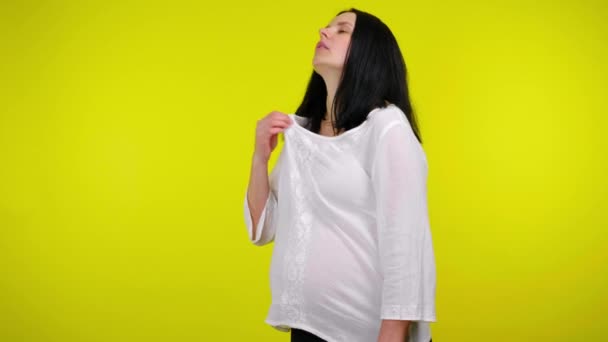 Es ist sehr heiß für eine junge schwangere Frau, nimmt Wasser in einer Plastikflasche — Stockvideo