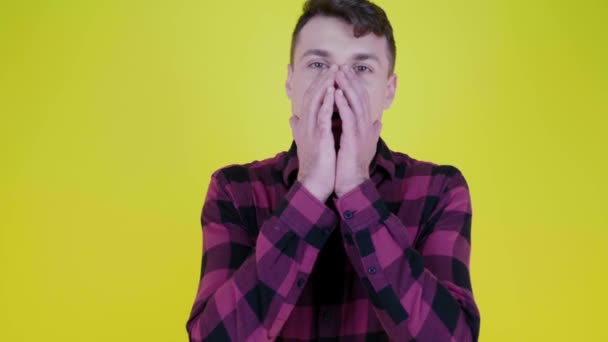 Muž se otočí ke kameře a šokován tím, co vidí, přikryje obličej rukama — Stock video