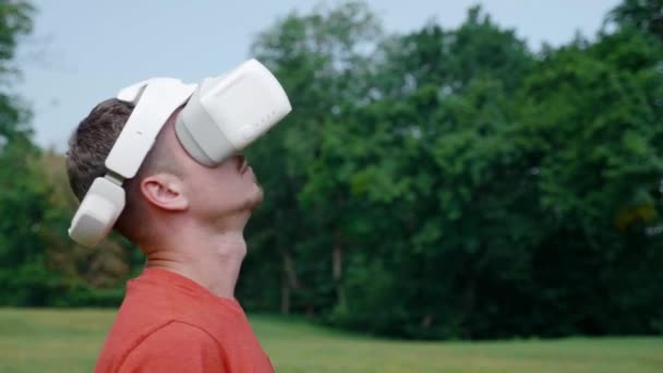 Man in een virtual reality helm bestudeert een virtual game — Stockvideo