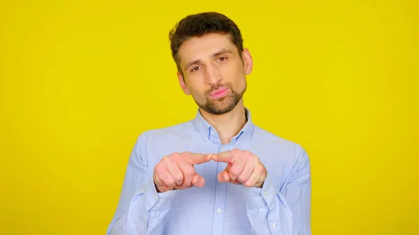 Bonito barbudo homem mostra gestos em um fundo amarelo com copyspace — Fotografia de Stock