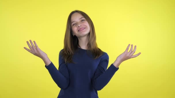 Joyful tiener meisje rechte haar met handen op gele achtergrond — Stockvideo