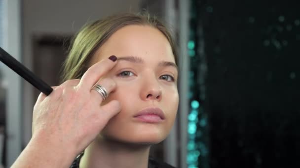 Meisje tiener met make-up zit op een stoel in een schoonheidssalon — Stockvideo