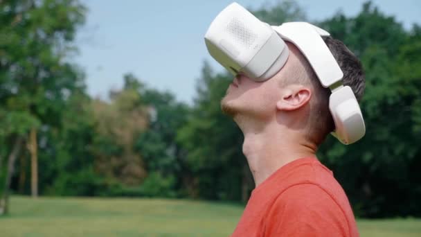 Homem em um capacete realidade virtual levanta a cabeça — Vídeo de Stock