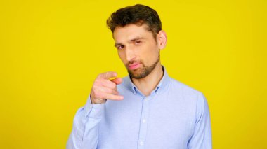 Erkek flört eder ve sarı arka planda kopyalanmış bir kızı işaret eder.