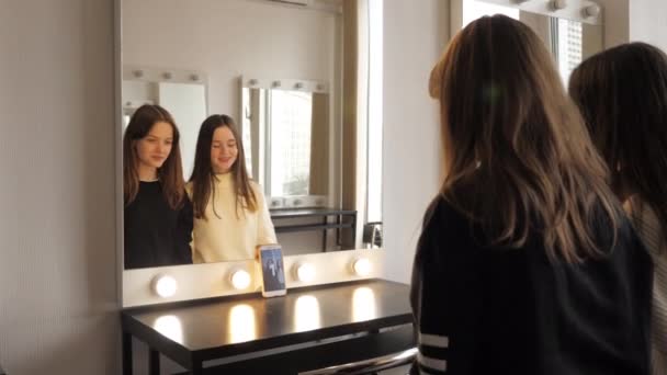 Girls dance in front of a mirror, record video on a selfie camera of smartphone — Stock Video