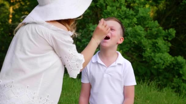 Mamma lägger grön druvmust i munnen, pojken tuggar, äter och njuter av smaken — Stockvideo