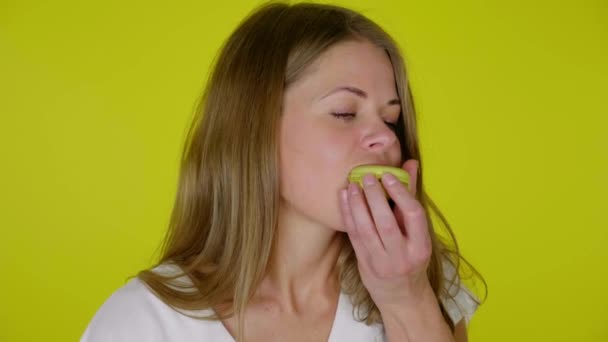 Kapalı kadın sarı bir badem kurabiyesini ısırır, dudaklarını yalar, yer ve şöyle gösterir: — Stok video