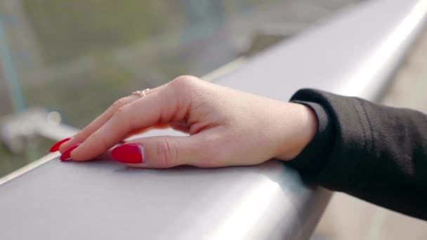 歩道橋の金属製の手すりに女性の手を閉じます — ストック動画