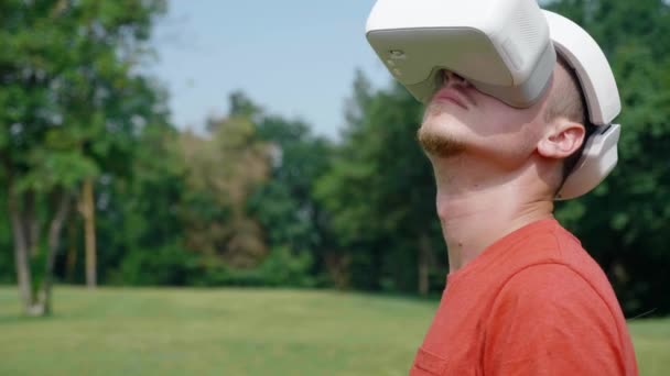 Man i en virtuell verklighet hjälm vänder huvudet åt vänster och upp — Stockvideo