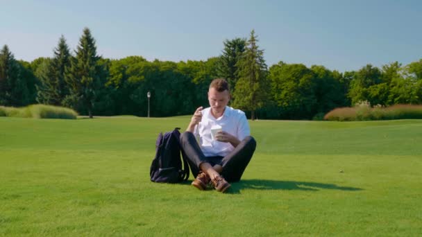 Zakenman neemt een vegetarische lunch uit een rugzak en eet — Stockvideo