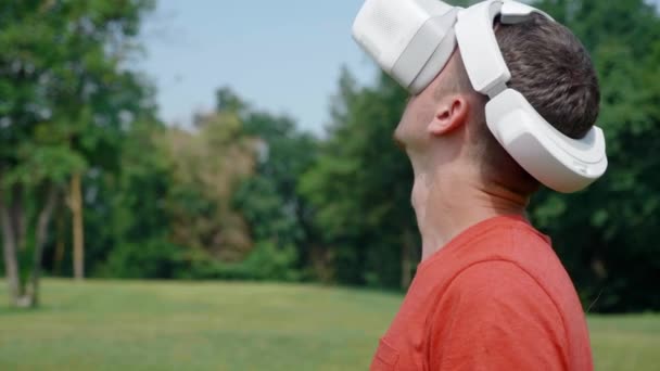 Homme dans un casque de réalité virtuelle tourne la tête vers la droite et vers le haut — Video